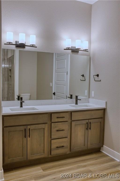 bathroom with vanity, toilet, and hardwood / wood-style floors