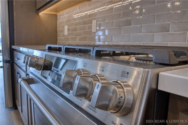 room details featuring tasteful backsplash and stainless steel gas range oven