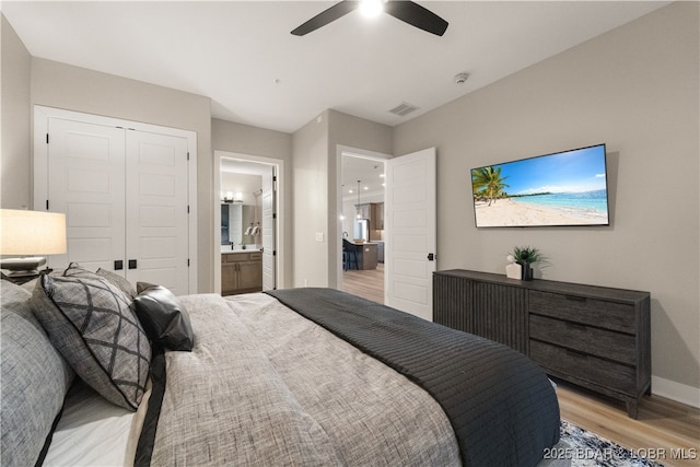 bedroom with visible vents, connected bathroom, ceiling fan, light wood-style floors, and a closet
