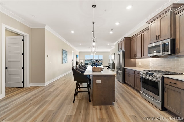 1184 Jeffries Rd Unit 519, Osage Beach, MO 65065 - kitchen with appliances with stainless steel finishes, light wood-style floors, crown molding, decorative backsplash, and a breakfast bar area