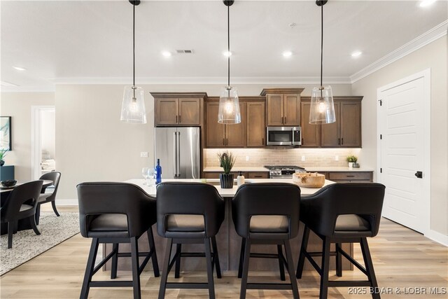 1184 Jeffries Rd Unit 519, Osage Beach, MO 65065 - kitchen with stainless steel appliances, decorative backsplash, crown molding, light countertops, and a breakfast bar