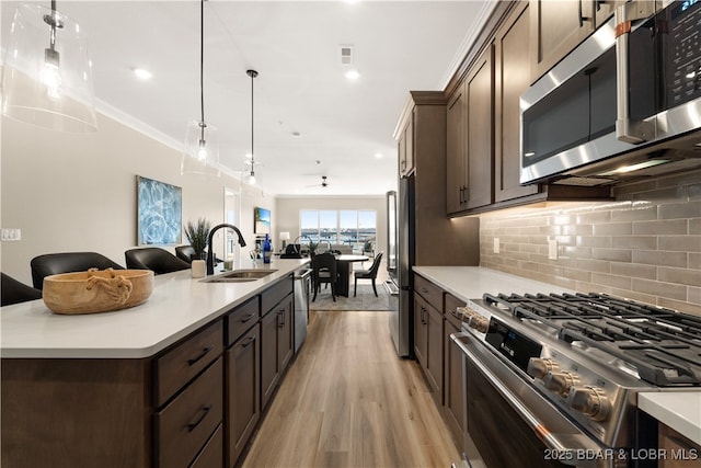 1184 Jeffries Rd Unit 519, Osage Beach, MO 65065 - kitchen with appliances with stainless steel finishes, light wood-type flooring, dark brown cabinets, backsplash, and light countertops