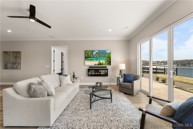 living room with recessed lighting, baseboards, ornamental molding, and light wood finished floors
