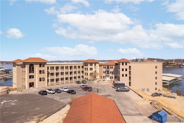 view of property with a water view and uncovered parking