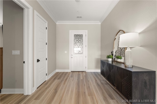 foyer featuring baseboards, visible vents, light wood finished floors, and ornamental molding