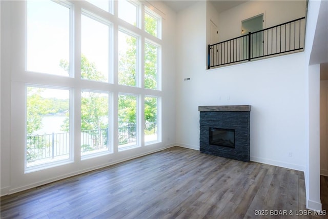 17023 Seminole Dr W, Rocky Mount, MO 65072 - unfurnished living room featuring a high ceiling, plenty of natural light, wood finished floors, and a stone fireplace