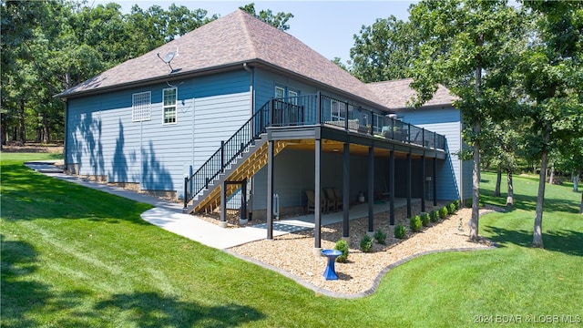 rear view of property with a deck, a lawn, and a patio