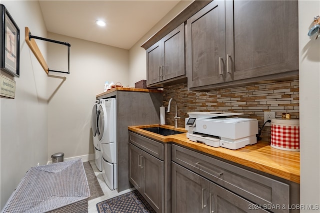 washroom featuring light tile patterned floors, washer and dryer, and sink