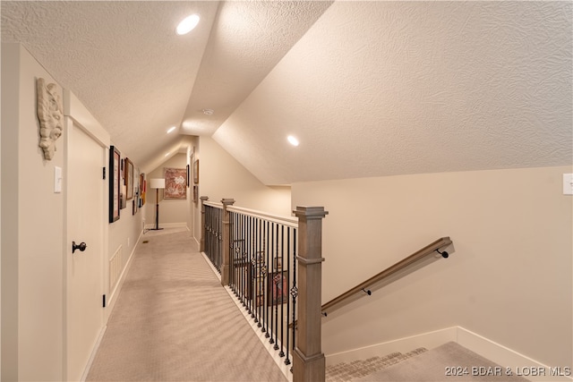 interior space with vaulted ceiling, a textured ceiling, and carpet floors