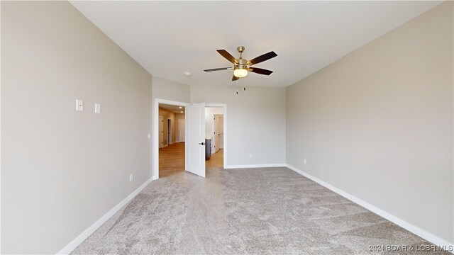 carpeted spare room with ceiling fan