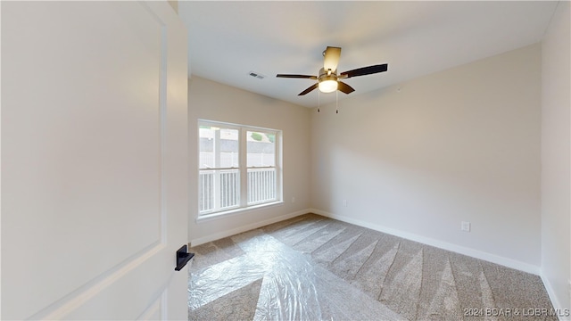 unfurnished room featuring light colored carpet and ceiling fan