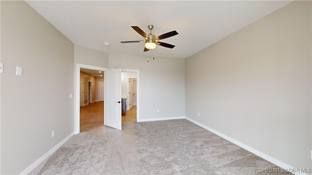 unfurnished bedroom with ceiling fan and light colored carpet