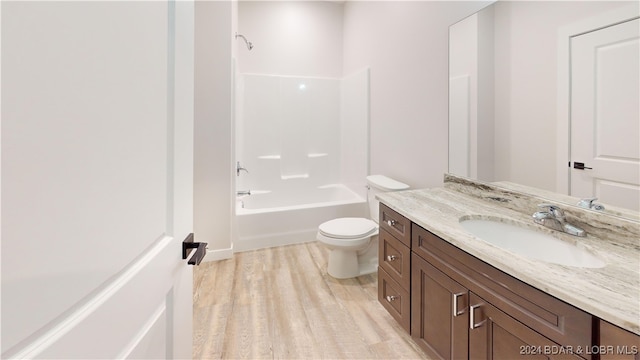 full bathroom featuring vanity, wood-type flooring, toilet, and bathing tub / shower combination