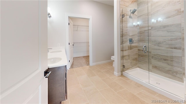 bathroom featuring vanity, toilet, tile patterned flooring, and an enclosed shower