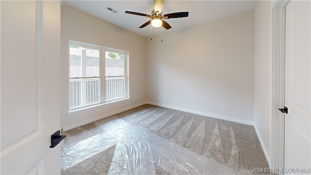 carpeted spare room featuring ceiling fan