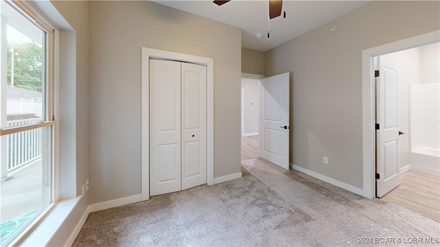 unfurnished bedroom with a closet, light carpet, and ceiling fan