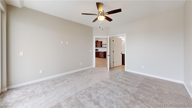 carpeted spare room with ceiling fan