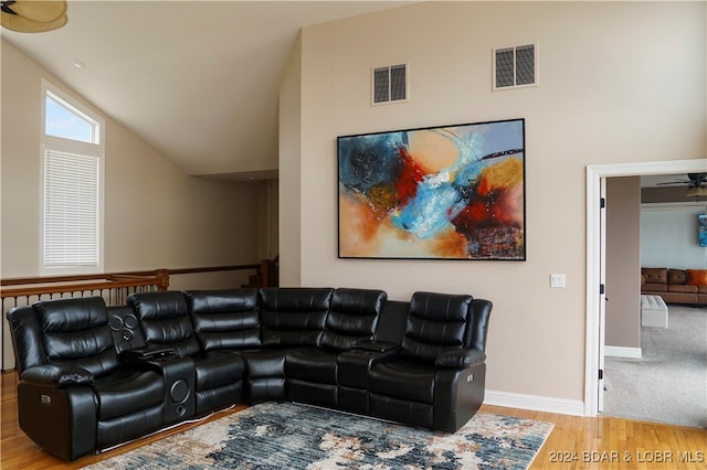 living room featuring light hardwood / wood-style flooring, ceiling fan, and vaulted ceiling