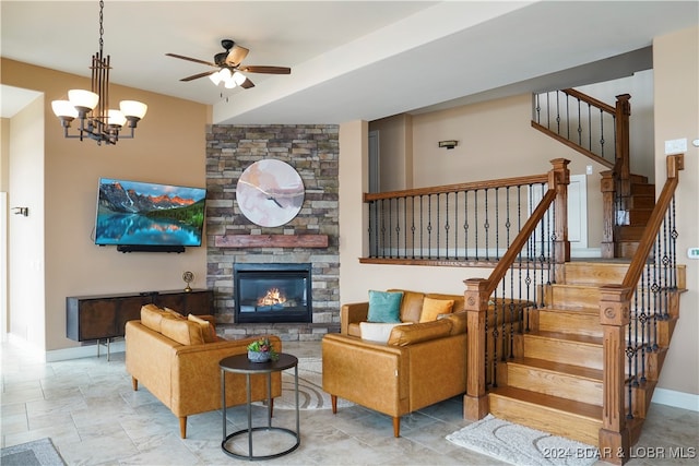 living room with a fireplace and ceiling fan with notable chandelier