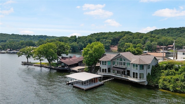 view of dock with a balcony and a water view