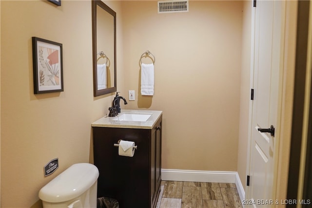 bathroom featuring vanity, toilet, and hardwood / wood-style floors