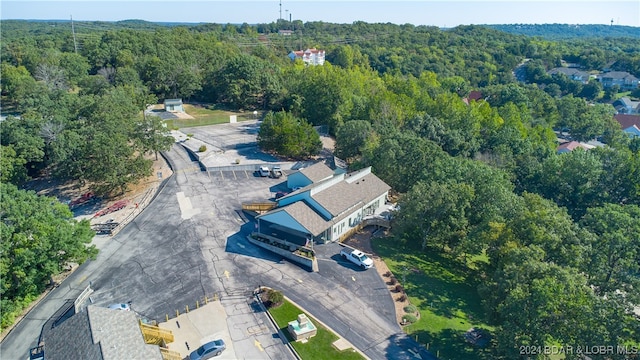 drone / aerial view featuring a wooded view