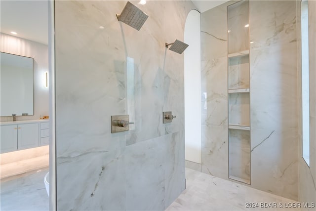 bathroom with vanity and tiled shower