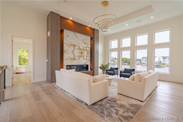 living room with a premium fireplace, a high ceiling, and plenty of natural light