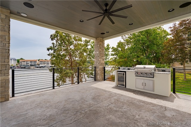 view of patio / terrace featuring wine cooler, an outdoor kitchen, a balcony, ceiling fan, and grilling area