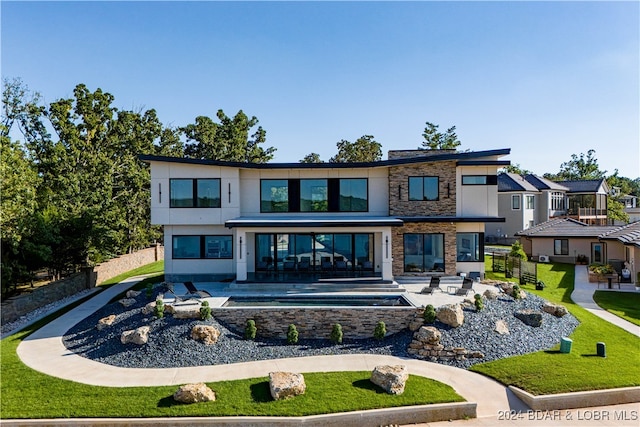 rear view of house with a lawn and a patio