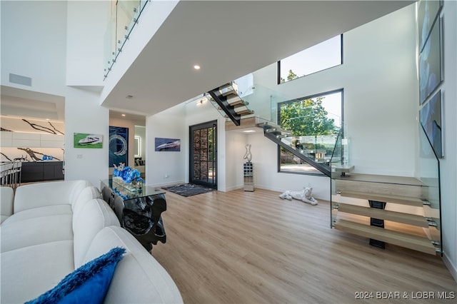 living room featuring a high ceiling and light wood-type flooring