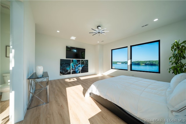 bedroom with light hardwood / wood-style flooring and connected bathroom