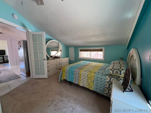 bedroom with ceiling fan, a textured ceiling, light carpet, and vaulted ceiling