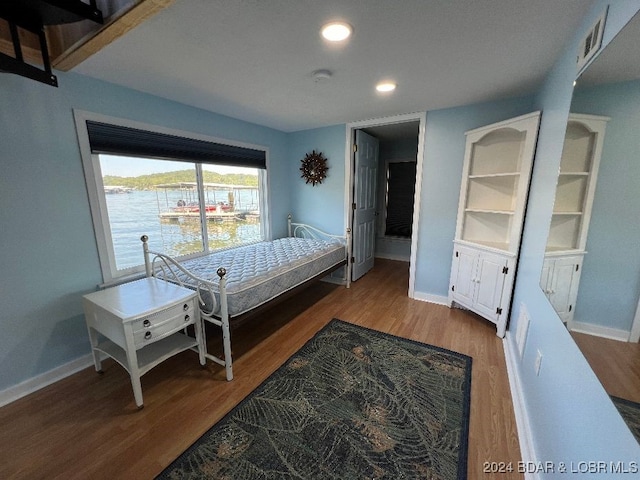 bedroom featuring a water view and wood-type flooring