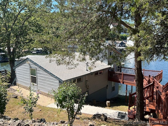 view of side of home with a deck with water view