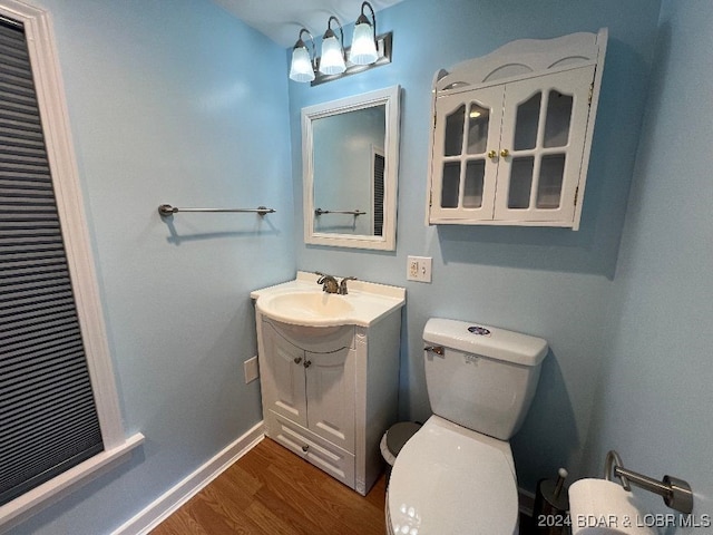 bathroom featuring toilet, vanity, and hardwood / wood-style floors