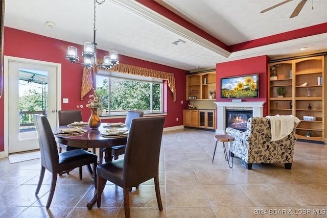 tiled dining space featuring plenty of natural light and ceiling fan with notable chandelier