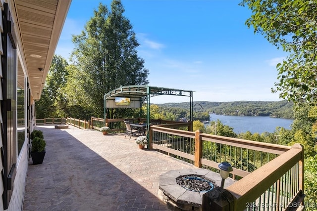 view of patio / terrace featuring a water view and a fire pit