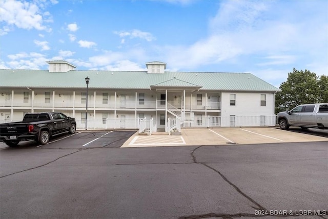 view of building exterior featuring fence and uncovered parking