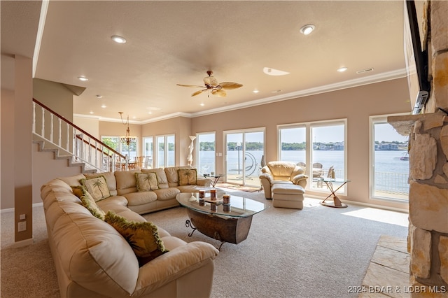 living room featuring ceiling fan, light carpet, a water view, and a wealth of natural light