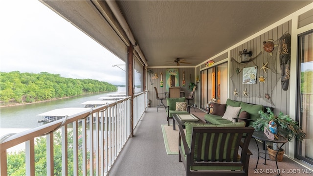 balcony with ceiling fan and a water view