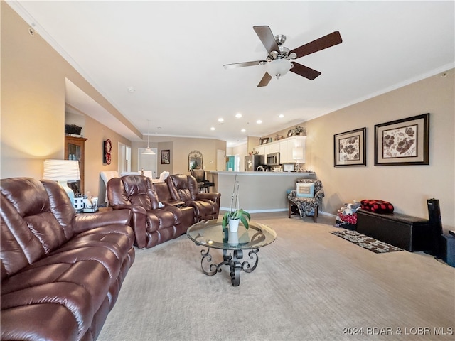 living room with ornamental molding, light carpet, and ceiling fan