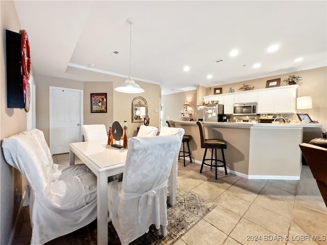 dining room featuring crown molding and light tile patterned floors