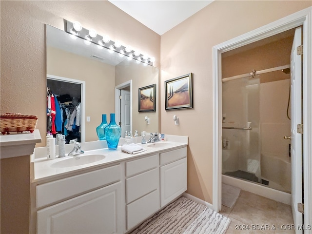 bathroom featuring vanity, a shower with shower door, and tile patterned flooring