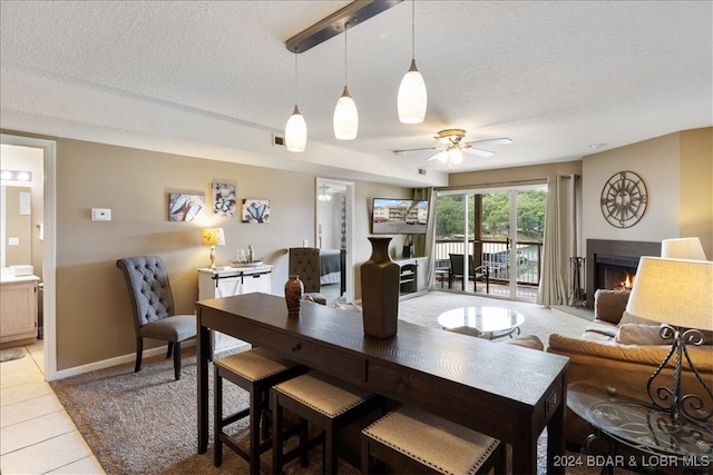 tiled dining room with ceiling fan and a textured ceiling