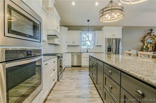 kitchen featuring hanging light fixtures, white cabinetry, and appliances with stainless steel finishes