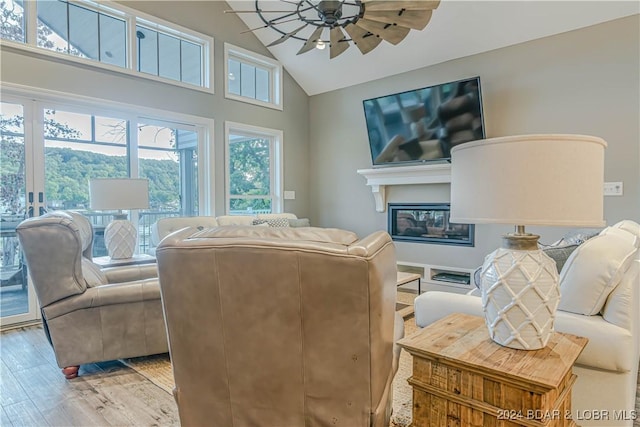 living room featuring high vaulted ceiling, light wood-type flooring, and ceiling fan