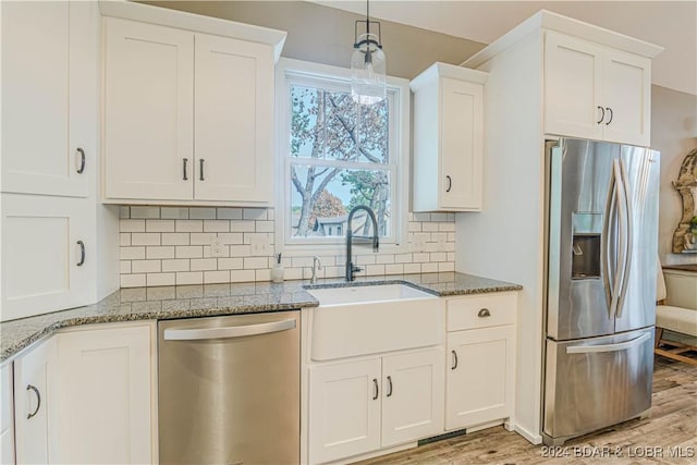 kitchen with appliances with stainless steel finishes, sink, and white cabinets