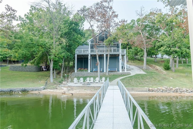 dock area featuring a water view and a lawn