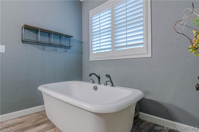 bathroom with a tub and hardwood / wood-style floors